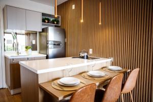 uma cozinha com uma mesa com cadeiras e um frigorífico em Habitarte - Studio Luxo Brooklin em São Paulo