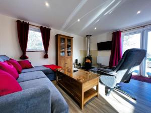 a living room with a couch and a desk at Cherry Lodge in Godshill