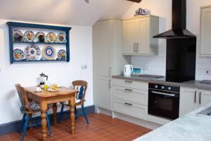 a kitchen with a small wooden table and chairs at Fedwen Uchaf Tresaith in Penbryn