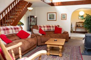 a living room with two brown couches and a table at Fedwen Uchaf Tresaith in Penbryn