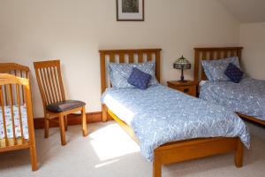 a bedroom with two beds and a table and chairs at Fedwen Uchaf Tresaith in Penbryn