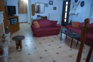 a living room with a purple couch and a table at Gaia garden house in Gáïa