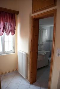 a bathroom with a tub and a toilet and a window at Gaia garden house in Gáïa +22 photos