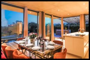 a dining room with a table and chairs and a kitchen at Villa Cristal in Sète