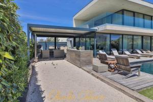 a house with a deck with chairs and a pool at Villa Cristal in Sète