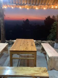 a wooden table and benches on a patio with a view at Homestay Chân Núi in Sa Pả