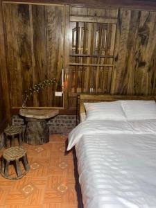 a bedroom with a large bed and a table at Homestay Chân Núi in Sa Pả