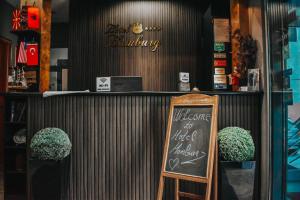 a bar with a chalkboard sign in a restaurant at Hotel Hamburg in Skopje