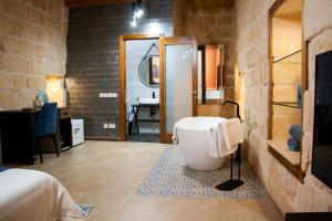 a bathroom with a tub and a sink in a room at Sea Holly Gozo in Nadur