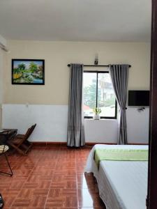 a hotel room with two beds and a window at RICE HOUSE HUE in Hue