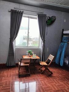 a room with a table and chairs and a window at RICE HOUSE HUE in Hue