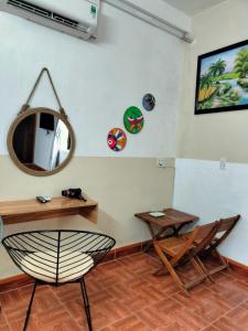 Zimmer mit einem Spiegel, einem Tisch und einem Stuhl in der Unterkunft RICE HOUSE HUE in Hue