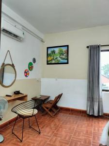 ein Zimmer mit einem Tisch und einem Stuhl und einem Spiegel in der Unterkunft RICE HOUSE HUE in Hue