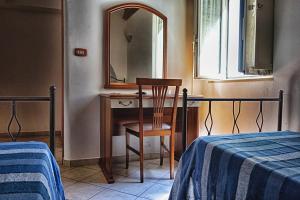 een slaapkamer met een tafel, een spiegel en een stoel bij B&B Sogni Goti in SantʼAgata deʼ Goti