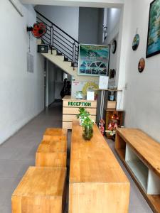 Zimmer mit 2 Holztischen und einer Treppe in der Unterkunft RICE HOUSE HUE in Hue + 19 Fotos