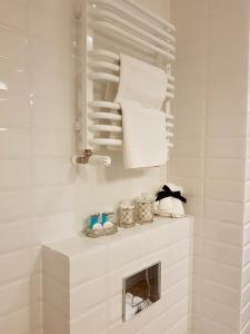 Baño blanco con toallas en un estante en Apartamenty Kielce- Apartament Zacisze przy Baseny Tropikalne, Kadzielnia, parking, faktura en Kielce
