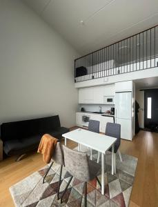 uma sala de estar com uma mesa branca e cadeiras em Spacious loft apartment with a lake view em Tampere