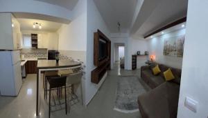 a living room and kitchen with a couch and a table at Apartment with three Rooms in Prijevor