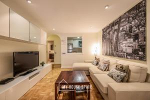 a living room with a couch and a tv at MyHouseSpain-Tranquilo apartamento con balcón in Madrid