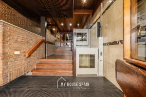 a hallway with stairs and a door in a brick wall at MyHouseSpain-Tranquilo apartamento con balcón in Madrid