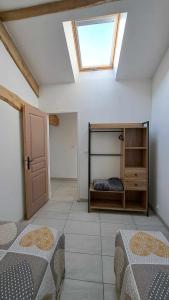 a bedroom with two beds and a skylight at Les Coccinelles in Adilly +15 photos