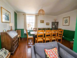 a living room with a couch and a table and chairs at Coastguard Cottage in Ventnor