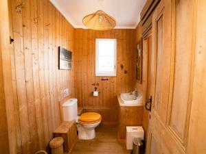 a wooden bathroom with a toilet and a sink at Coastguard Cottage in Ventnor