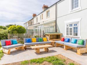 un gruppo di panchine di fronte a una casa di Coastguard Cottage a Ventnor