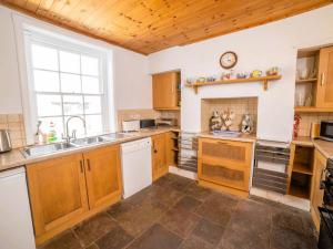 una cucina con armadi in legno e una grande finestra di Coastguard Cottage a Ventnor Altre 47 foto