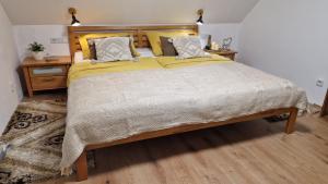 una camera da letto con un grande letto con lenzuola e cuscini gialli di Relax chata Helena Mikulášovice - České Švýcarsko na dosah a Mikulášovice