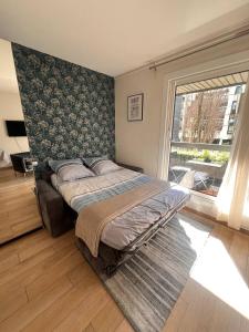 Un dormitorio con una cama grande y una ventana en Studio moderne, 10min à pied gare d'annecy, en Annecy