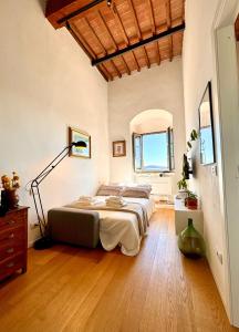 1 dormitorio con 1 cama grande y suelo de madera en La Torre di Canonica, en Colle Val D'Elsa