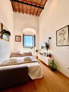1 dormitorio con 1 cama grande y espejo en La Torre di Canonica, en Colle Val D'Elsa