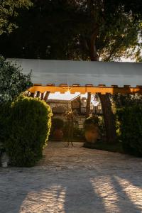 un parapluie blanc dans une cour avec des buissons dans l'établissement Tenuta Querce Grosse- Le Dimore, à Francavilla al Mare