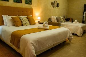 a hotel room with two beds with towels on them at Sea Holly Gozo in Nadur