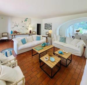 een woonkamer met witte banken en tafels bij Villa Bianca in Porto Ercole