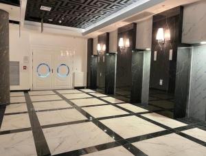 a lobby with two doors and a tiled floor at Hanza Tower Gold - 24 Pool & SPA in Szczecin