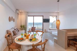 a dining room and living room with a table and chairs at Kohili Suite Stegna Beach in Archangelos