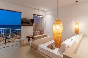 a bedroom with a bed and a view of the ocean at Kohili Suite Stegna Beach in Archangelos