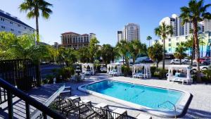 a swimming pool with chaise lounge chairs next to a city at Ivory Sands Beach Suites in Clearwater Beach