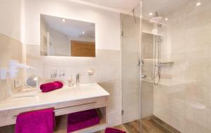 bagno con lavandino, doccia e asciugamani viola di Landhaus Pichler a Tannheim Altre 39 foto