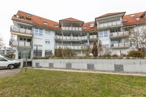 un edificio de apartamentos con un coche aparcado delante de él en Hotz, en Radolfzell am Bodensee