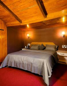 una camera da letto con un grande letto e soffitti in legno di Woodside Bungalow1 a Ooty