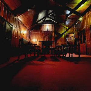 a dark room with chairs and a piano in a building at Woodside Bungalow1 in Ooty