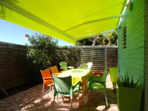 patio con tavolo e sedie sotto un ombrellone giallo di  La kaz a coyoky ad Anse-Bertrand