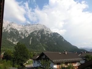 mit Blick auf eine Bergkette mit einem Haus in der Unterkunft Ferienwohnung Brunnsteinnest in Mittenwald