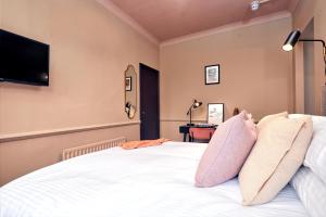 sypialnia z białym łóżkiem i telewizorem z płaskim ekranem w obiekcie Settle in Winchester - Self Check-In Serviced Rooms w mieście Winchester