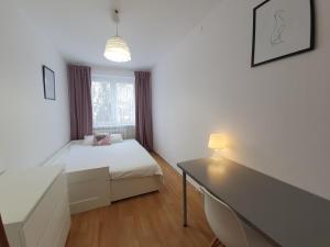 - une chambre avec un lit, un bureau et une fenêtre dans l'établissement Mieszkanie Gdańsk Zaspa, à Gdańsk