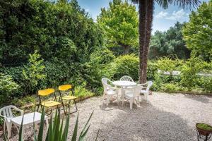 eine Gruppe von Stühlen sowie ein weißer Tisch und Stühle in der Unterkunft Quadrilocale con giardino e posto auto a Sirolo - S266 in Sirolo