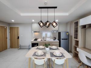 a kitchen with a white table and chairs in a room at modern 2 bedrooms,Ayuttaya in Ban Ko Rian
